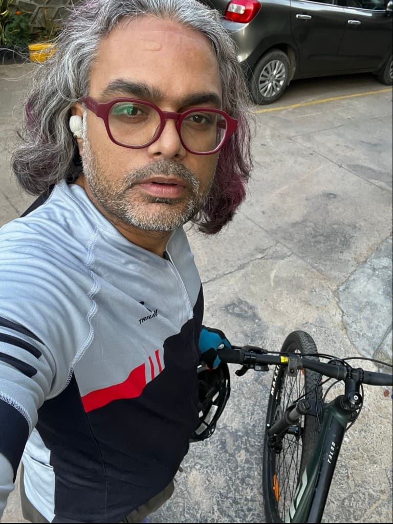After a ride, standing next to a Giant Talon mountain bike with helmet in hand.